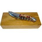 Folded corkscrew lying on top of the engraved oak gift box