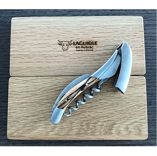 Corkscrew with lever raised resting on the engraved Laguiole en Aubrac oak lid