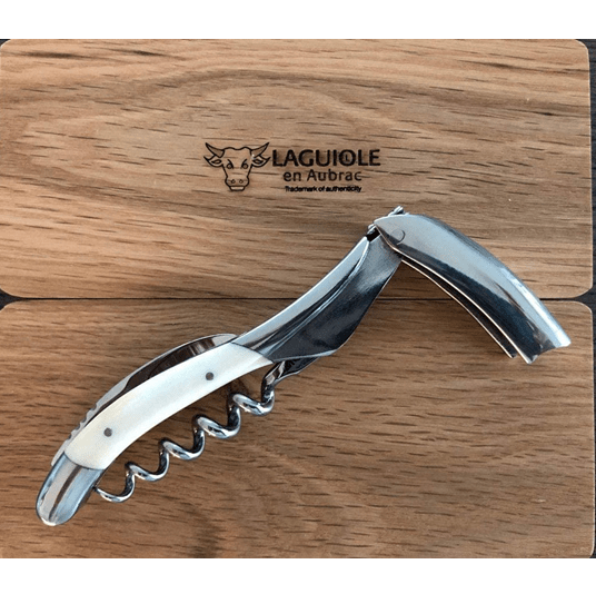 Corkscrew with the lever raised on the oak box lid