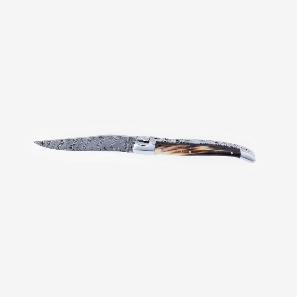 Laguiole Balbach Damascus horn knife open on a pale background