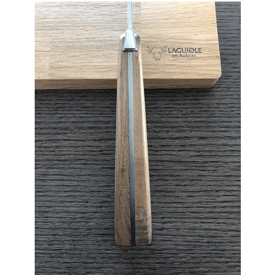 Cheese knife standing handle up against the engraved oak box