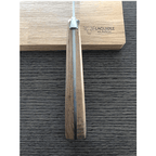 Cheese knife standing handle up against the engraved oak box