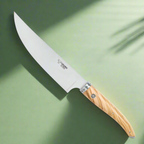 Chef's knife on a green background with soft leaf shadows
