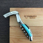 Blue camel bone corkscrew with lever raised on an engraved Laguiole en Aubrac oak box lid