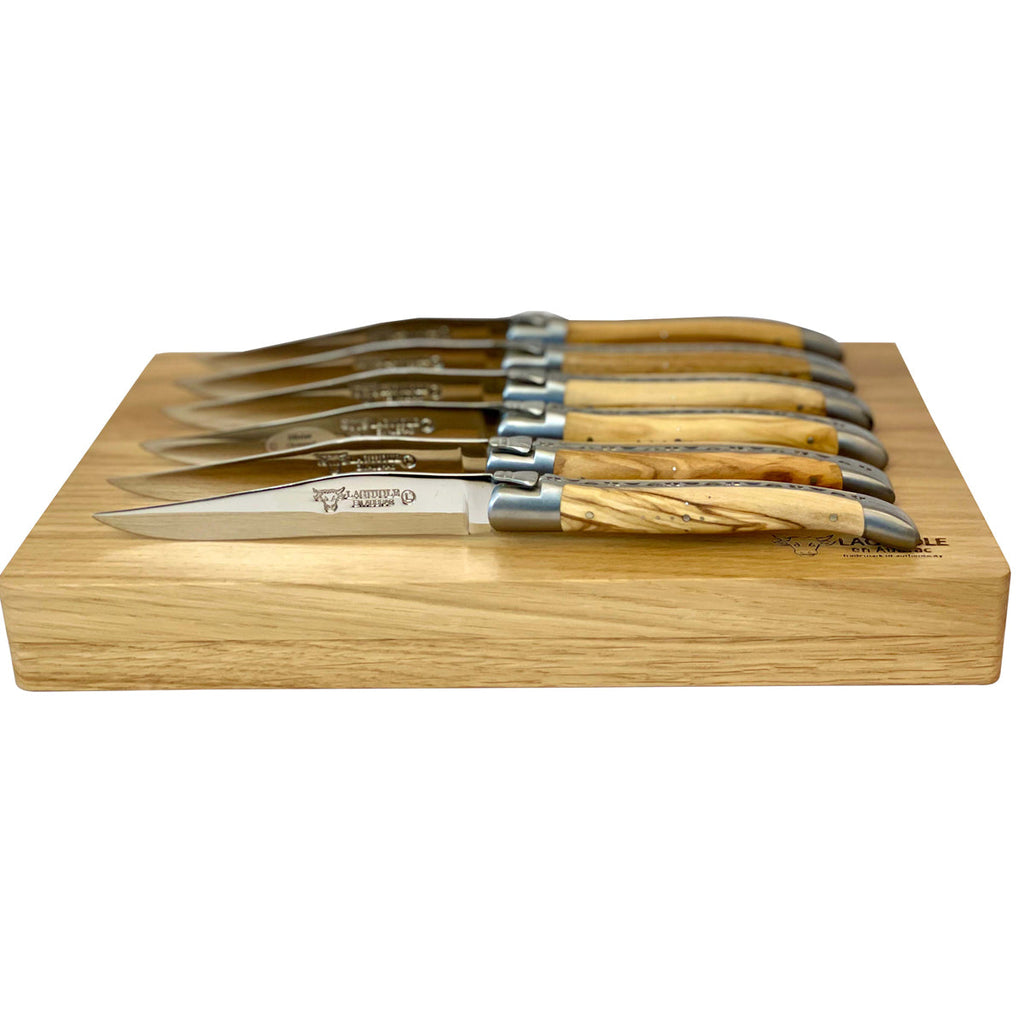 Knives fanned along the edge of the wooden box