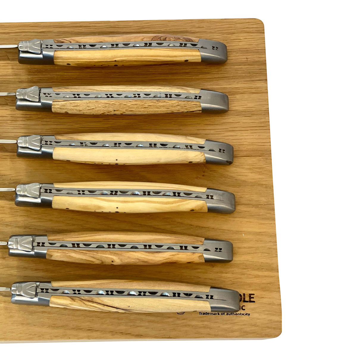 Close view of six carved spines and olive wood handles
