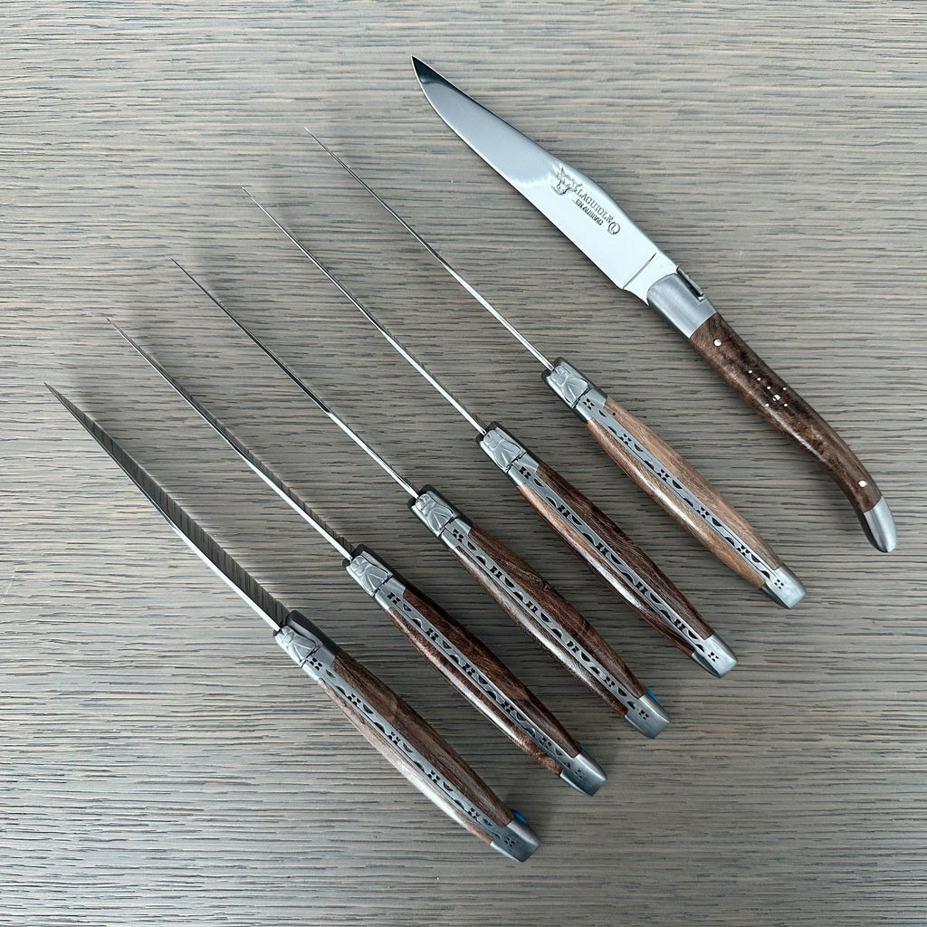 Knives laid out with one turned to show the blade