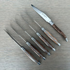Knives laid out with one turned to show the blade