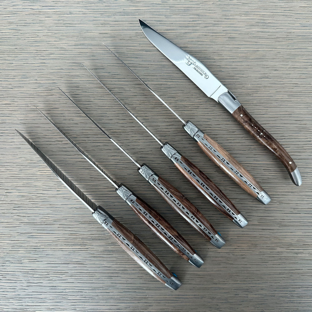Knives laid out with one turned to show the blade