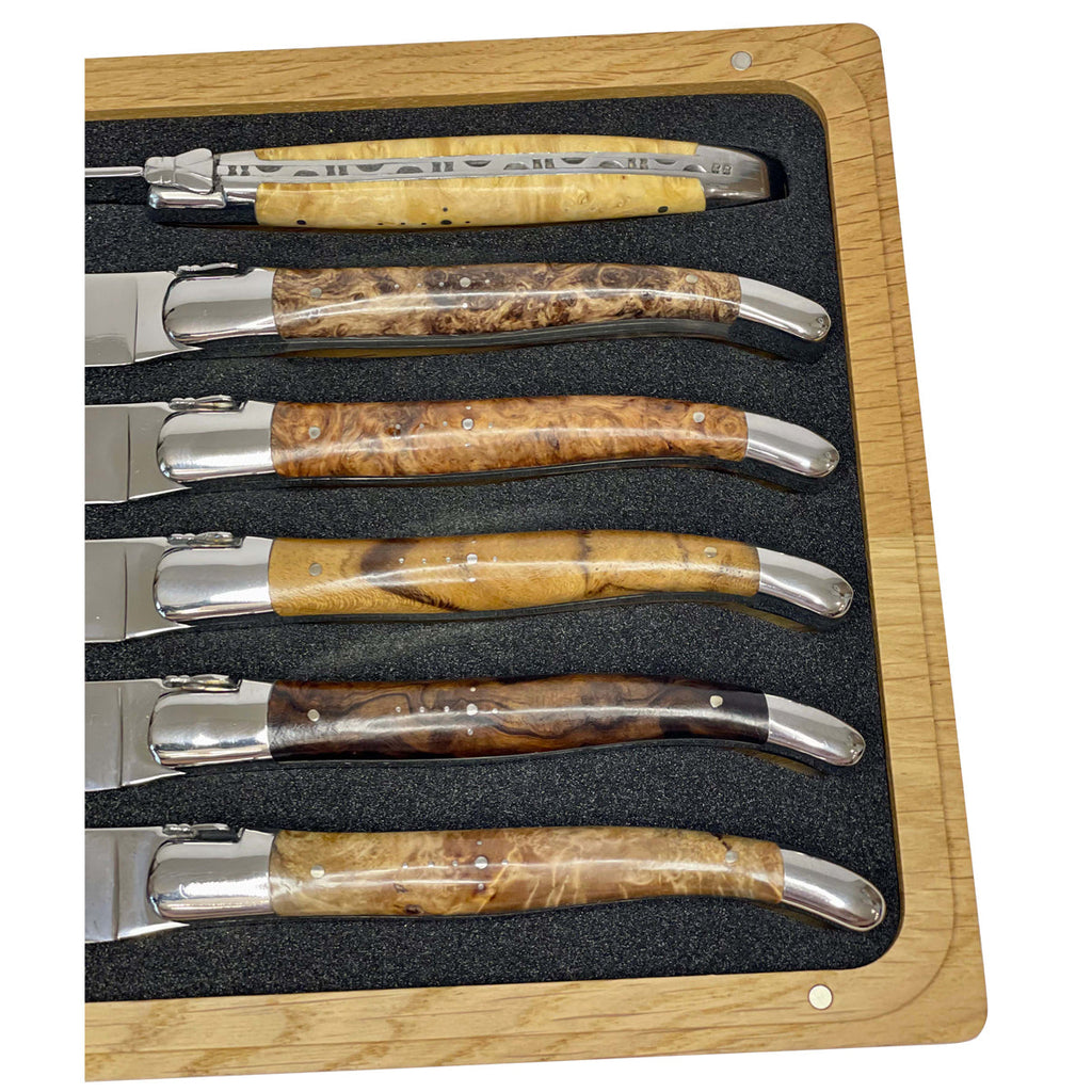 Close view of the burl handles and shiny bolsters in the foam tray