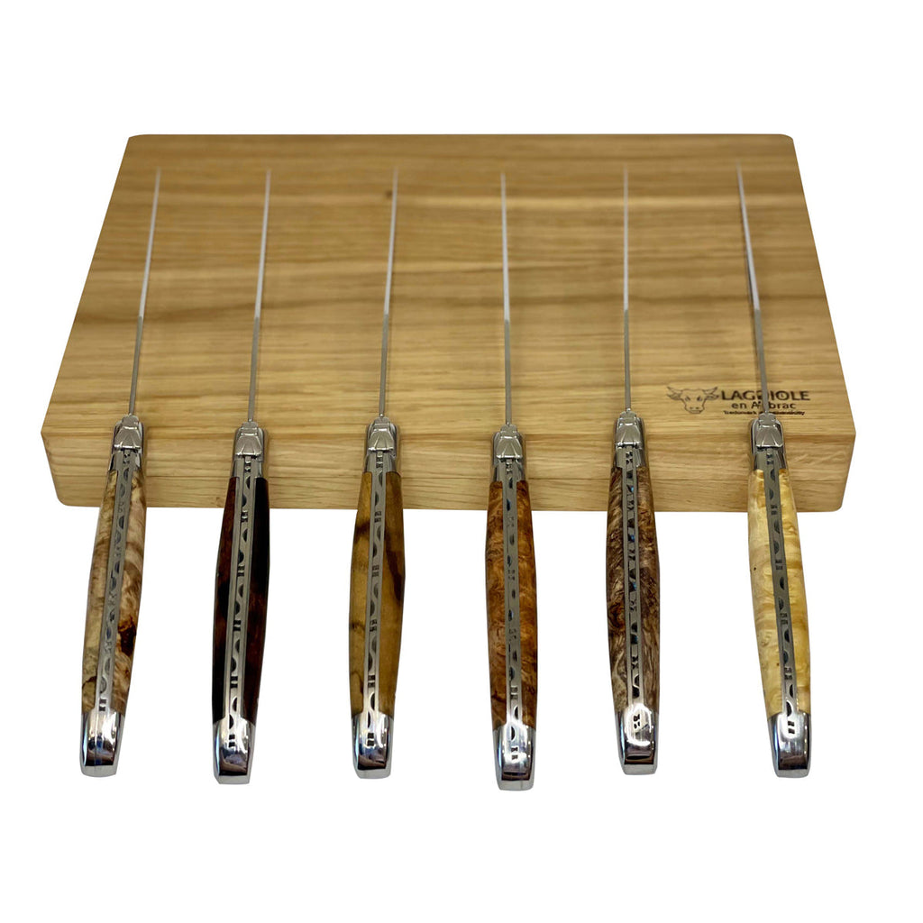 Six burl handled knives standing upright against the box, blades up