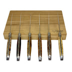 Six burl handled knives standing upright against the box, blades up