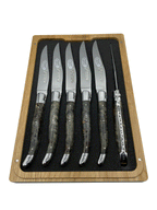 Six smoky burl handled knives standing upright in the foam tray