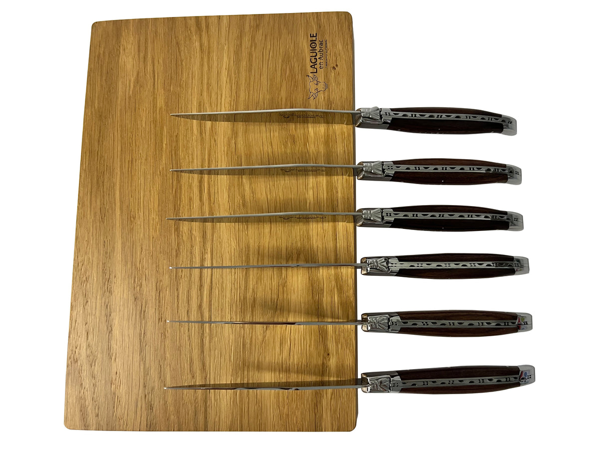 Six knives laid across the wooden box lid