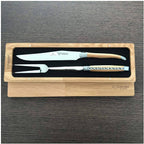 Boxed carving set on a dark wood surface