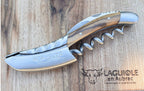 Corkscrew on a wood board beside the Laguiole en Aubrac logo