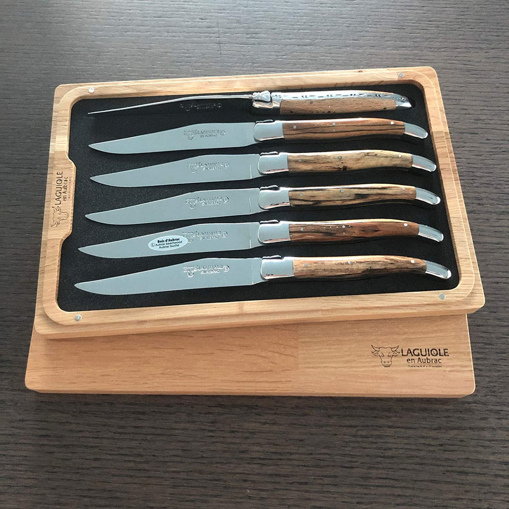 Boxed set on a dark table showing six streaked wood handles