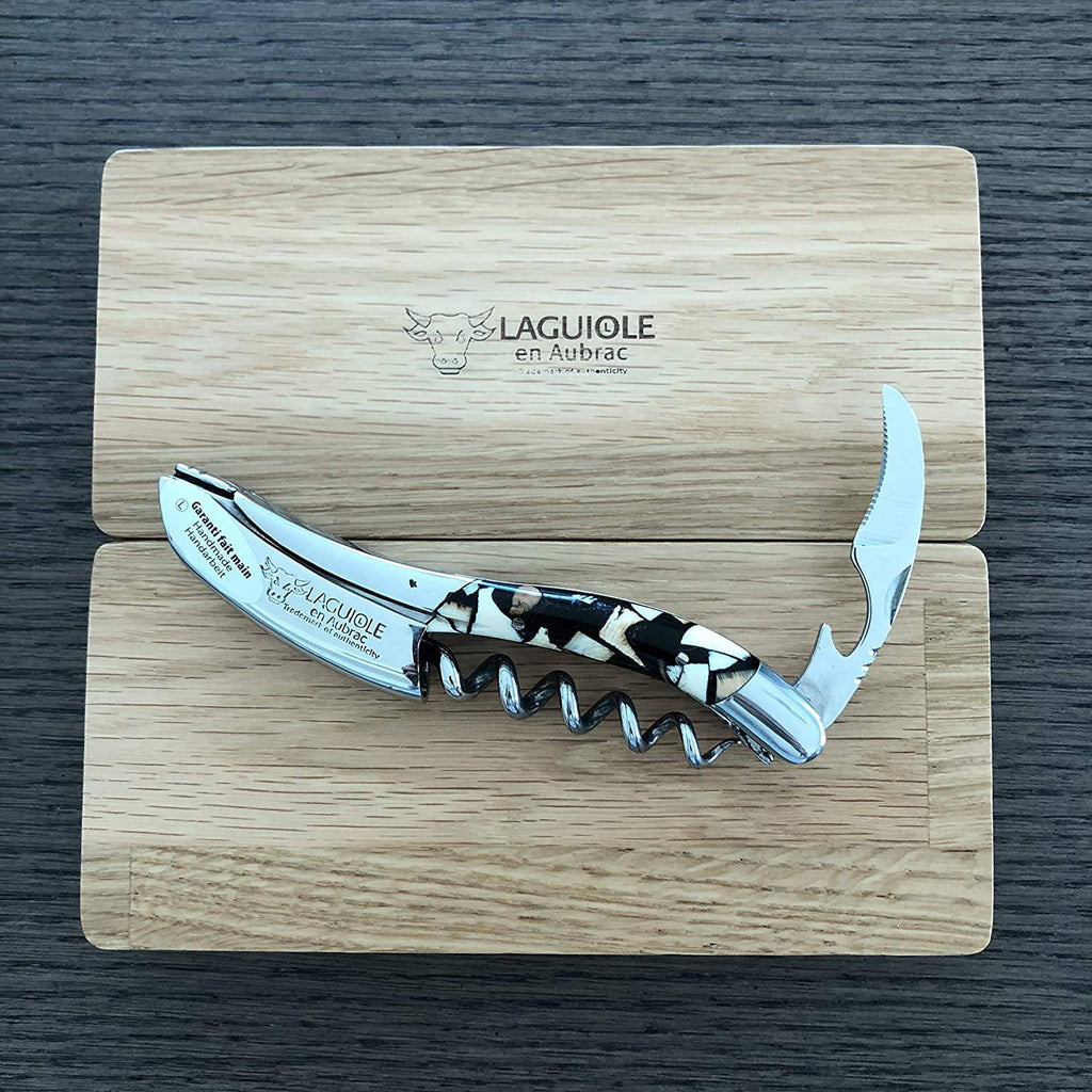 Corkscrew with foil cutter open resting on the Laguiole en Aubrac oak lid