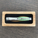 Folded corkscrew seen along its spine inside the oak gift box