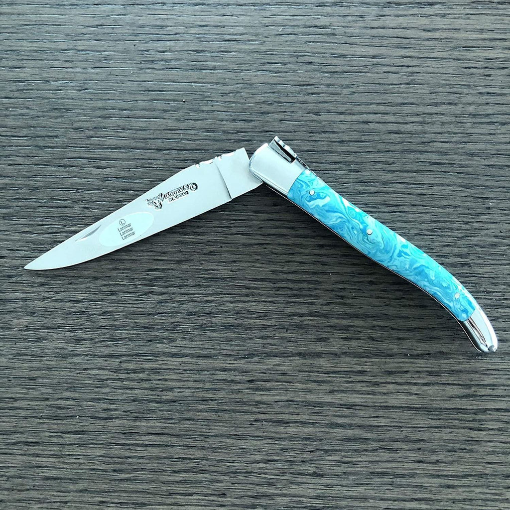 Turquoise handled knife half open on a dark wood surface