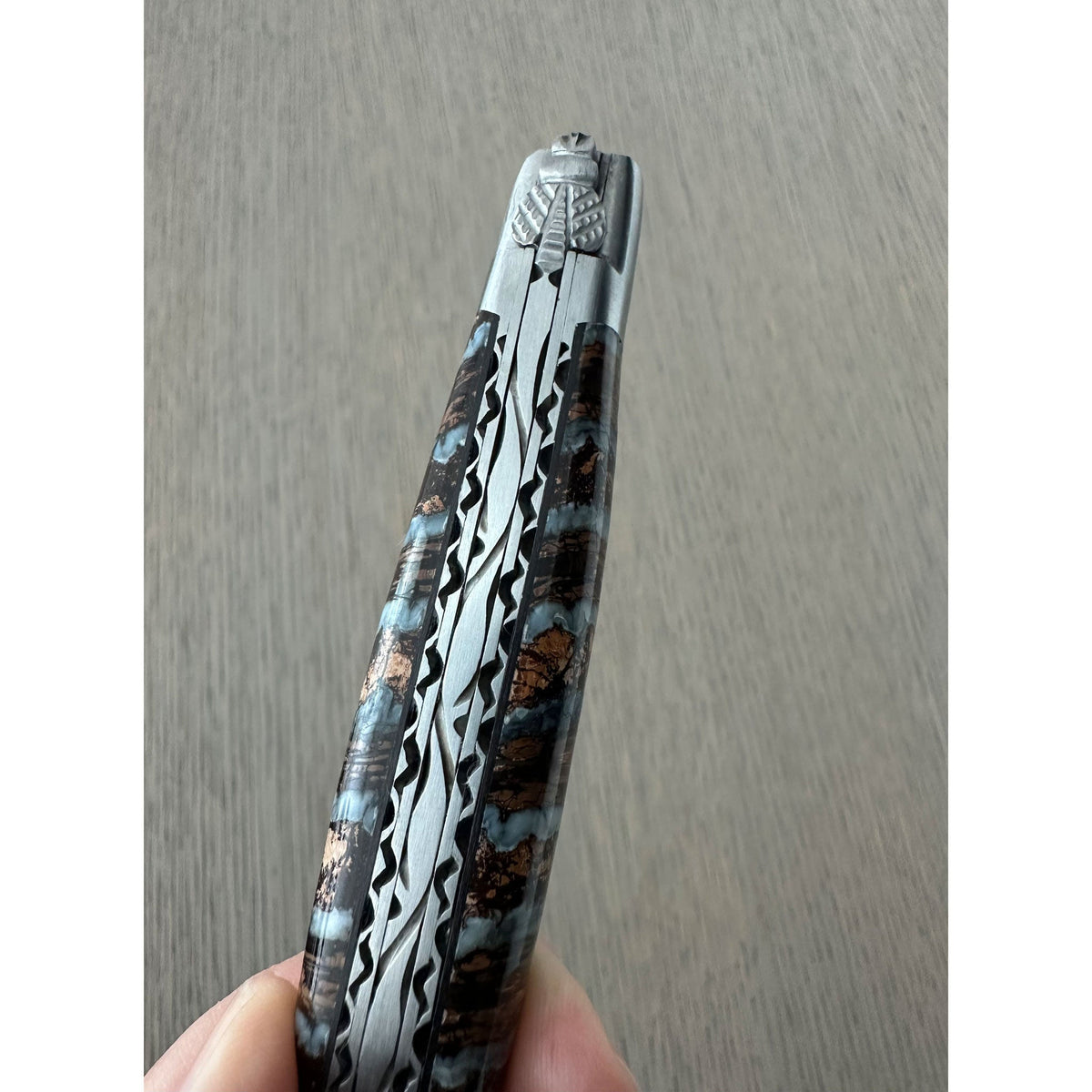 Close view of the molar handle held in a hand, showing the blue bands