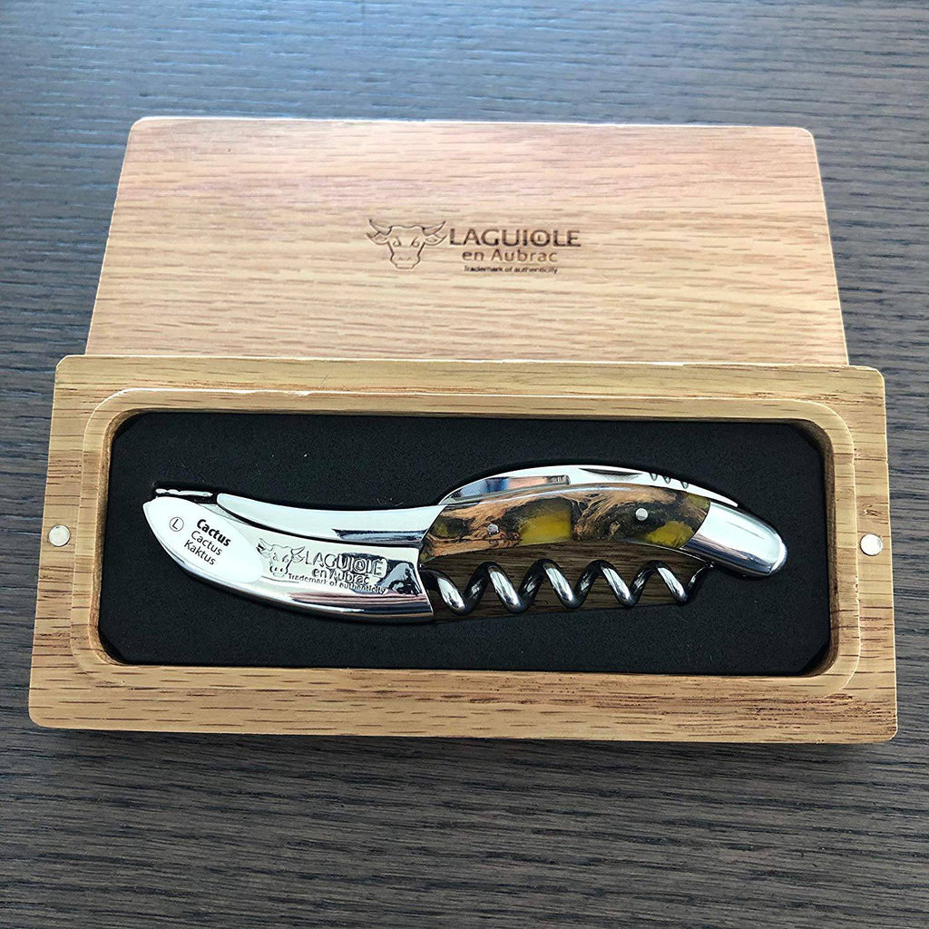 Amber cactus handled corkscrew in an open oak box on a dark table