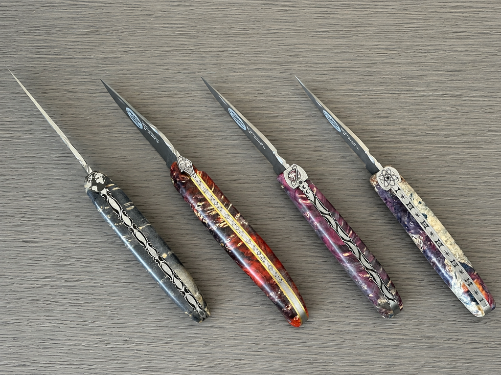 Four Cosmos knives laid side by side in different elder burl colours