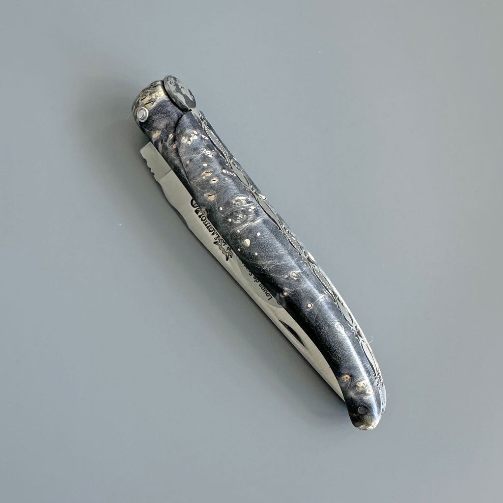 Closed dark burl knife at an angle
