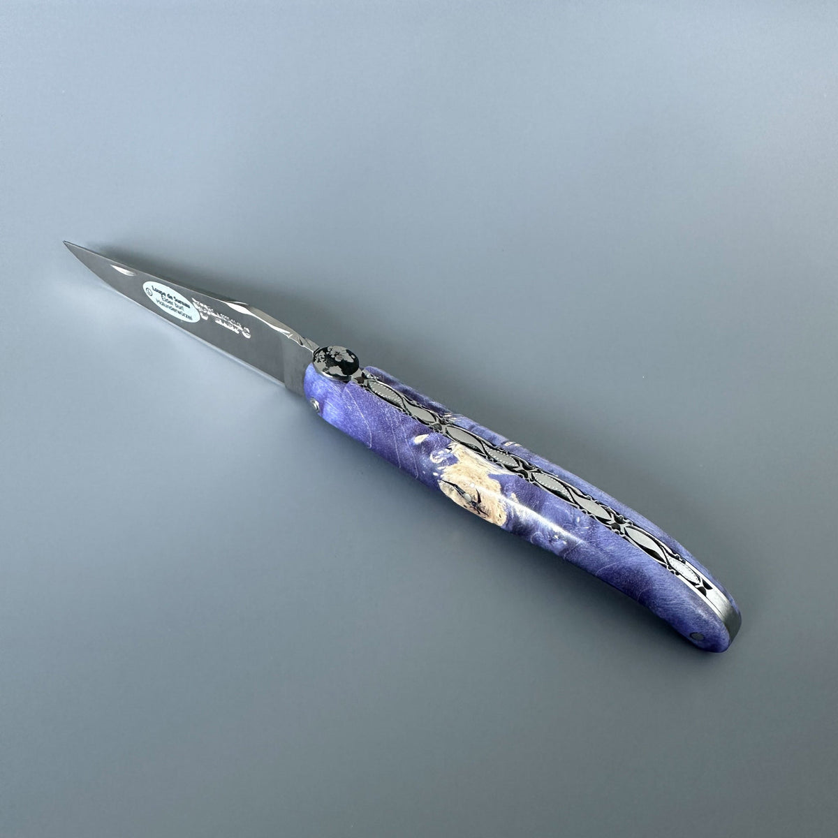 Open knife showing the matte blade and purple burl