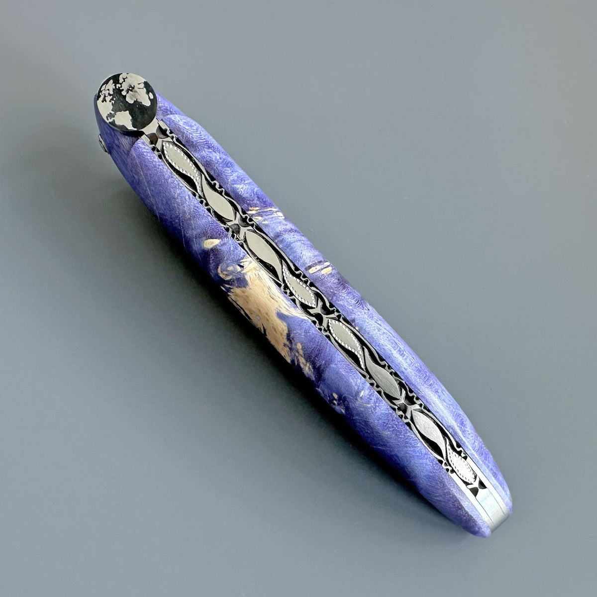 Close view of the engraved spring along the purple handle