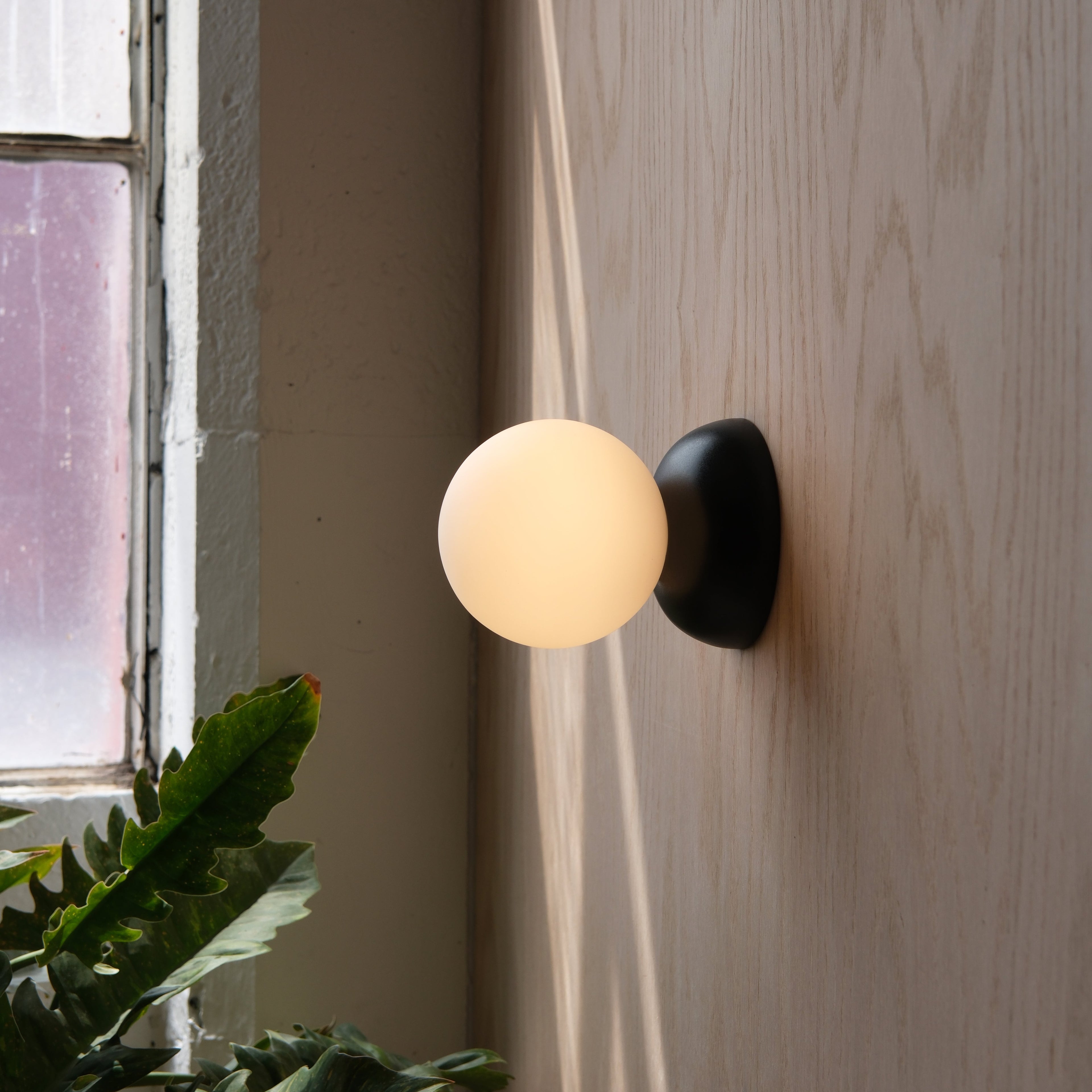 Monroe Sconce in White mounted on a hallway wall
