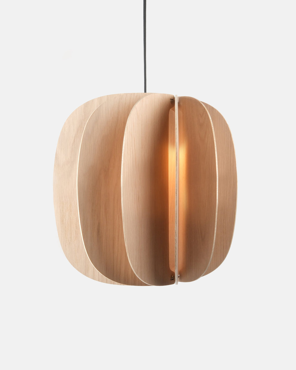 white oak cylinder pendant light over a dining table