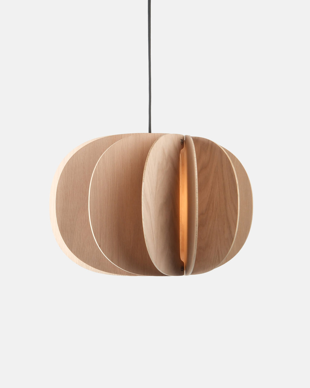 white oak drum pendant light hanging over a dining table