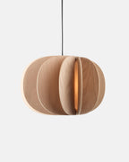 white oak drum pendant light hanging over a dining table
