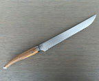 Serrated bread knife lying with the blade pointing up and right