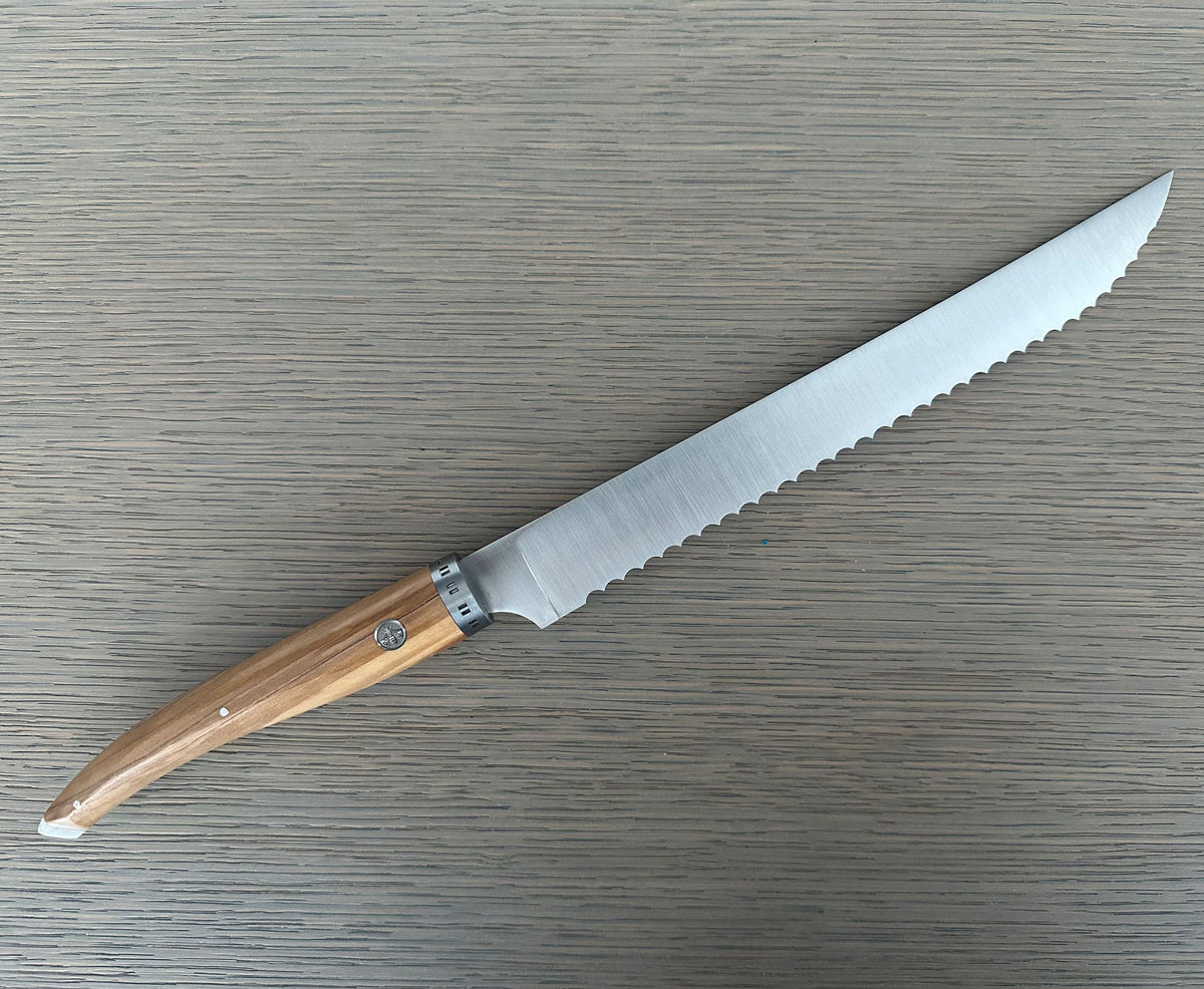 Serrated bread knife lying with the blade pointing up and right