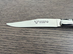 Single steak knife blade with the engraved logo on a wood surface