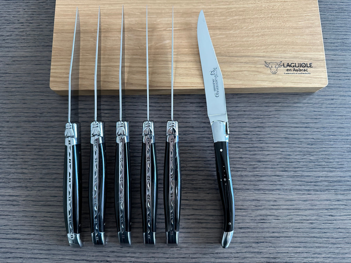 Six knives standing upright with one turned to show the blade