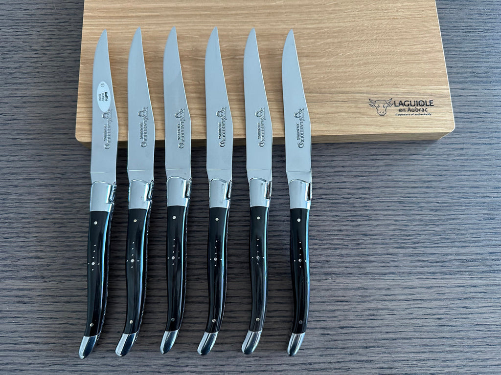 Six knives standing upright against the box with blades facing up