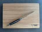 One steak knife lying diagonally on the engraved wooden box