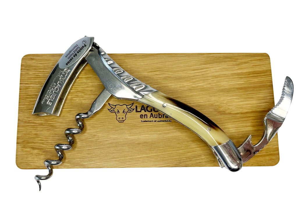 Opened corkscrew laid on the oak box lid with the spiral out