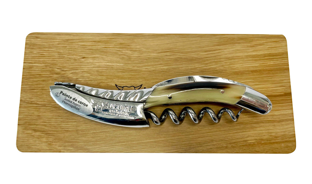 Folded horn corkscrew resting on the oak box