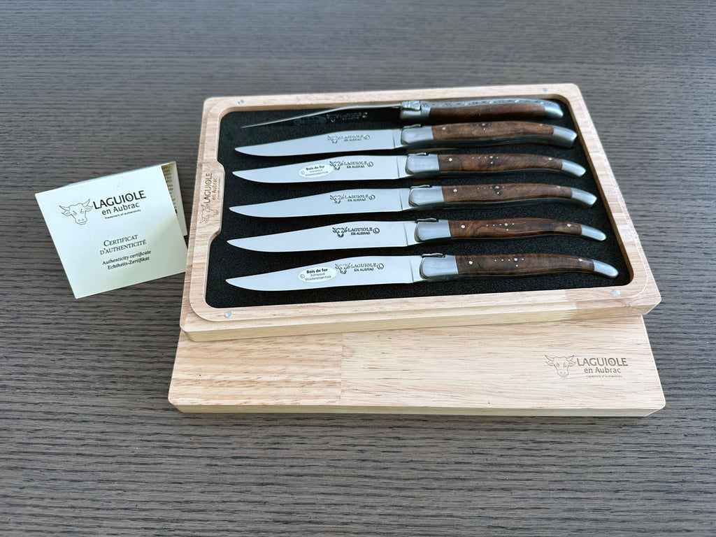 Boxed ironwood set with the certificate card on a grey table