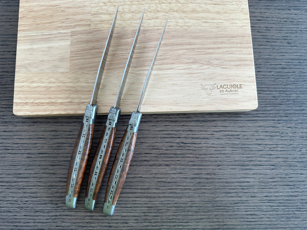 Three knives leaning against the box with blades up