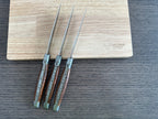 Three knives leaning against the box with blades up