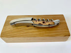 Corkscrew resting along the top of the closed oak box