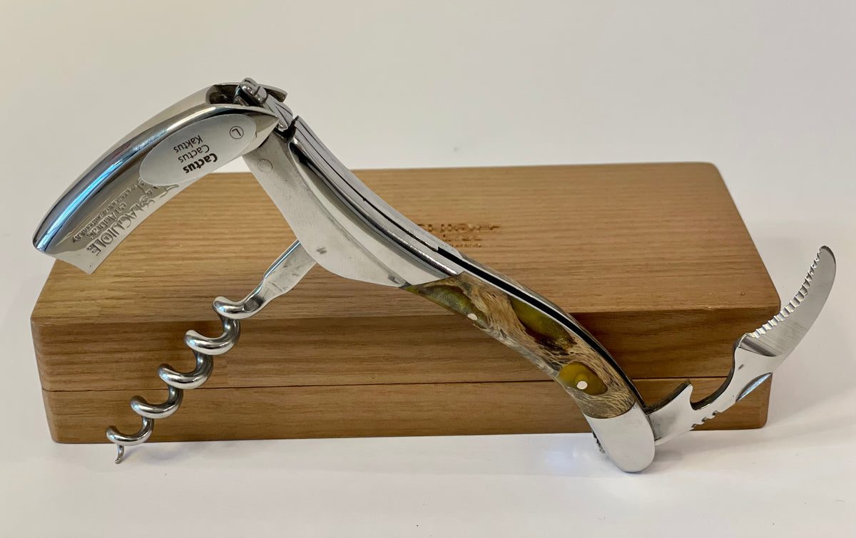 Opened corkscrew standing on the oak box with the lever and spiral out