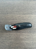 Black sheath opened with the snap and a knife tucked inside