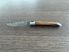 Open Damascus knife with the blade pointing left