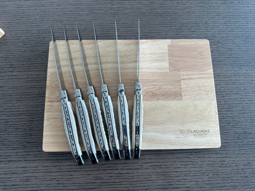 Six antler handled knives standing upright against the box